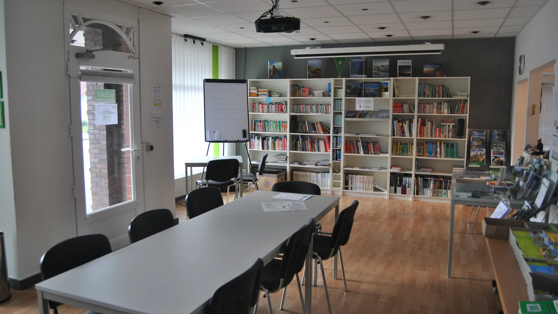 Geschaefstsstelle Innenbereich mit Tisch und Bücherregal  | © geschaefstsstelle-innenbereich