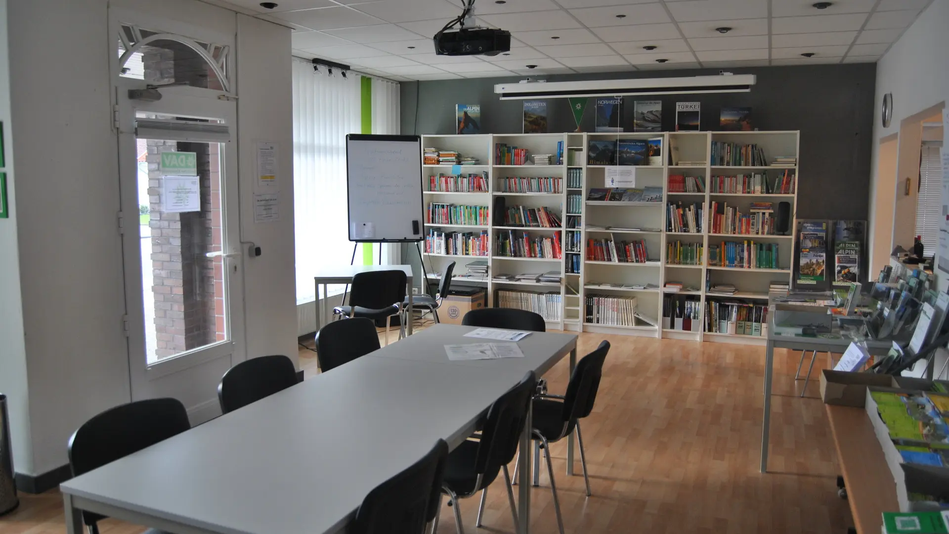 Geschaefstsstelle Innenbereich mit Tisch und Bücherregal  | © geschaefstsstelle-innenbereich