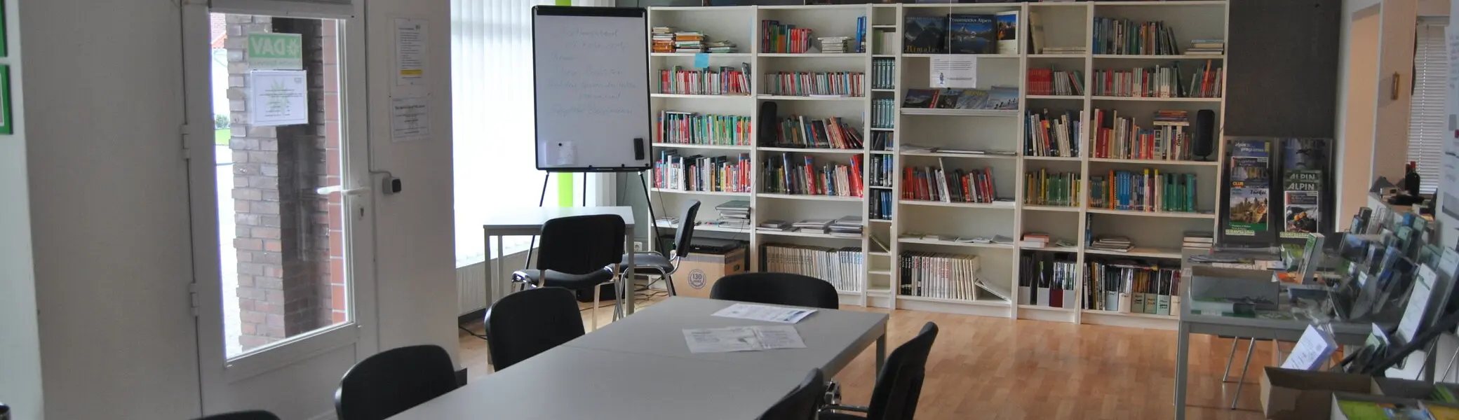 Geschaefstsstelle Innenbereich mit Tisch und Bücherregal  | © geschaefstsstelle-innenbereich