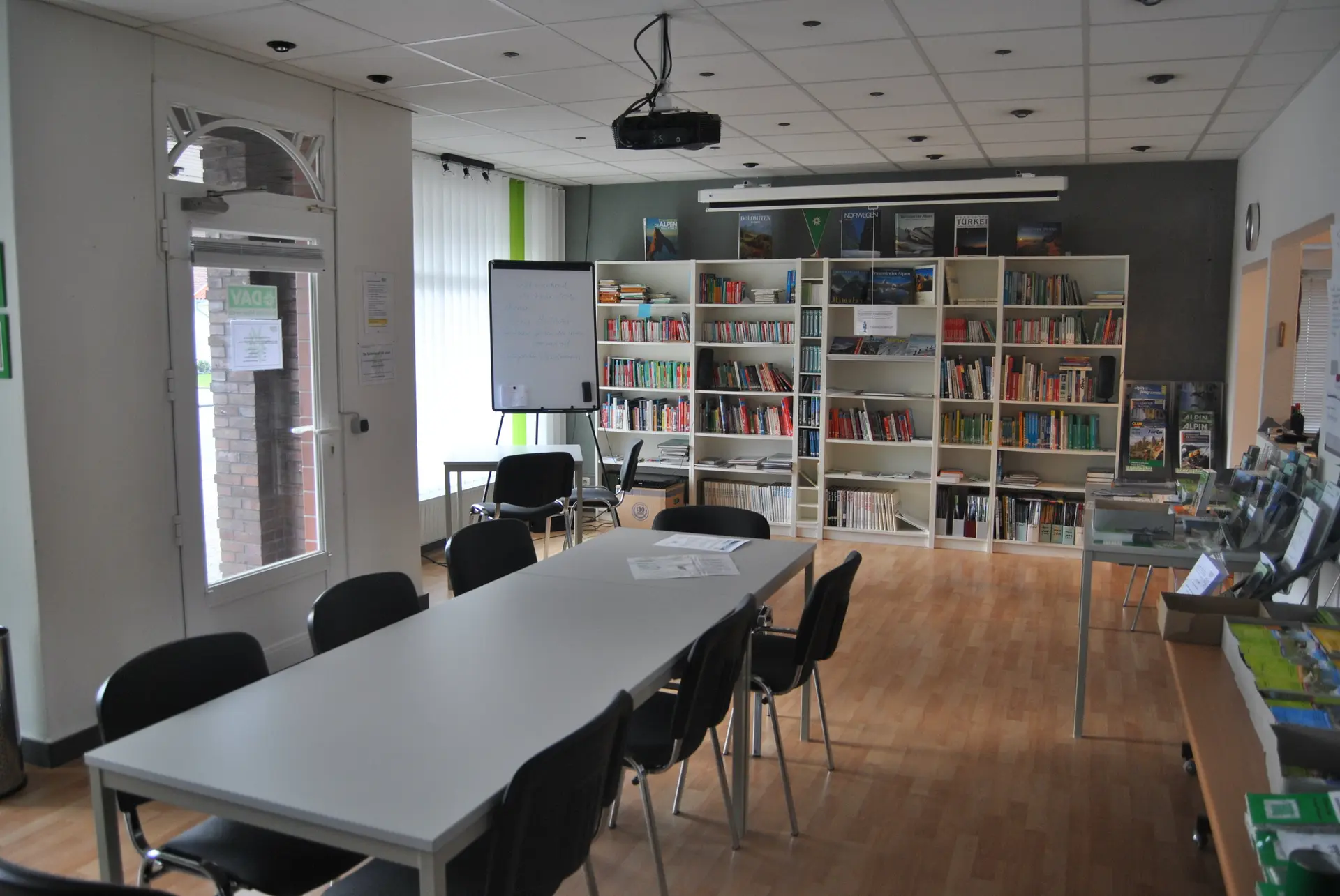 Geschaefstsstelle Innenbereich mit Tisch und Bücherregal  | © geschaefstsstelle-innenbereich