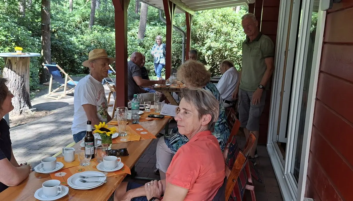Gäste des Sommerfestes sitzen auf der Terrasse der Poggenpohlhütte | © Werner Kaltenborn