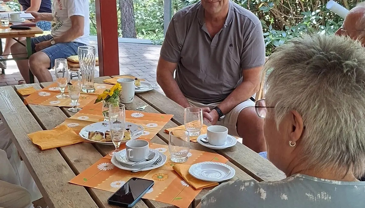 Gäste des Sommerfestes sitzen auf der Terrasse der Poggenpohlhütte | © Werner Kaltenborn