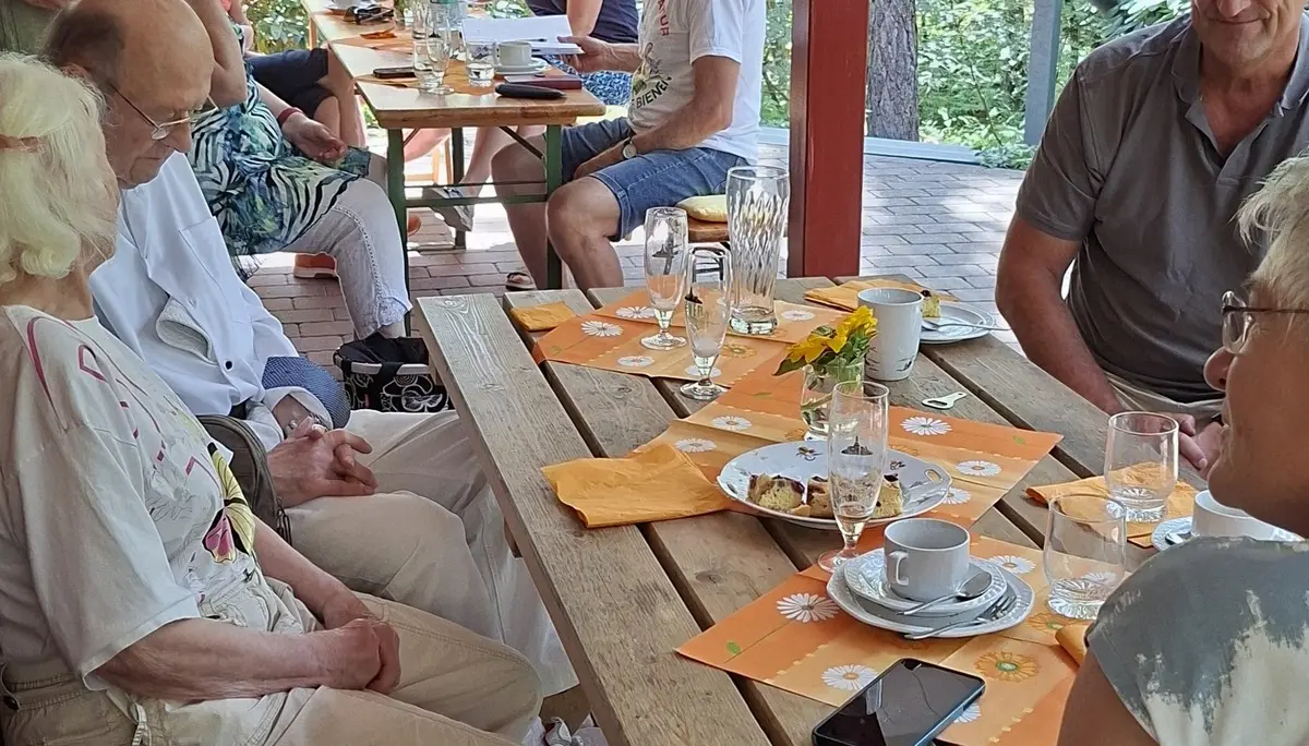 Gäste des Sommerfestes sitzen auf der Terrasse der Poggenpohlhütte | © Werner Kaltenborn