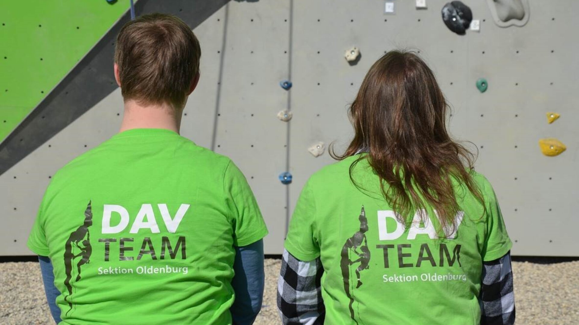 Foto von den Special Olympics Niedersachsen | © Ralf Holtgrefe Zwei Kletterer sitzen mit dem Rücken zur Kamera, auf den Shirts steht DAV Team | © Ralf Holtgrefe