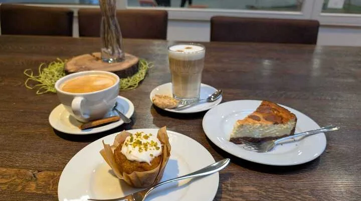 Auf einem Tisch stehen Tassen mit Kaffee und Teller mit Kuchen | © Kletterzentrum