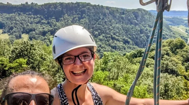 Ein Paar klettert am Felsen, hinter ihm ist ein Wald zu sehen | © Andreas Henke
