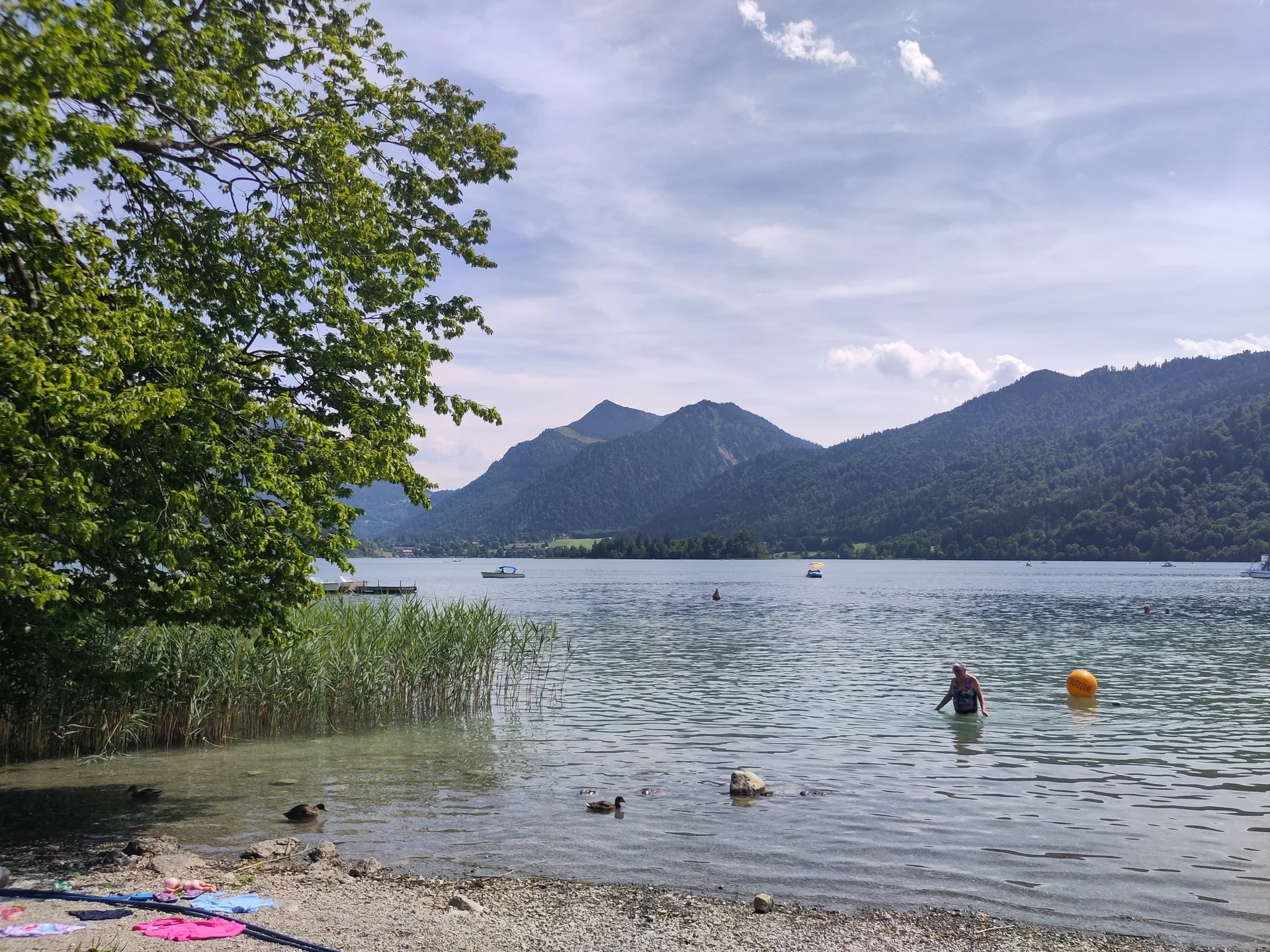 Ein See mit einem Badenden, im Hintergrund Berge | © Patrick Schönfeldt