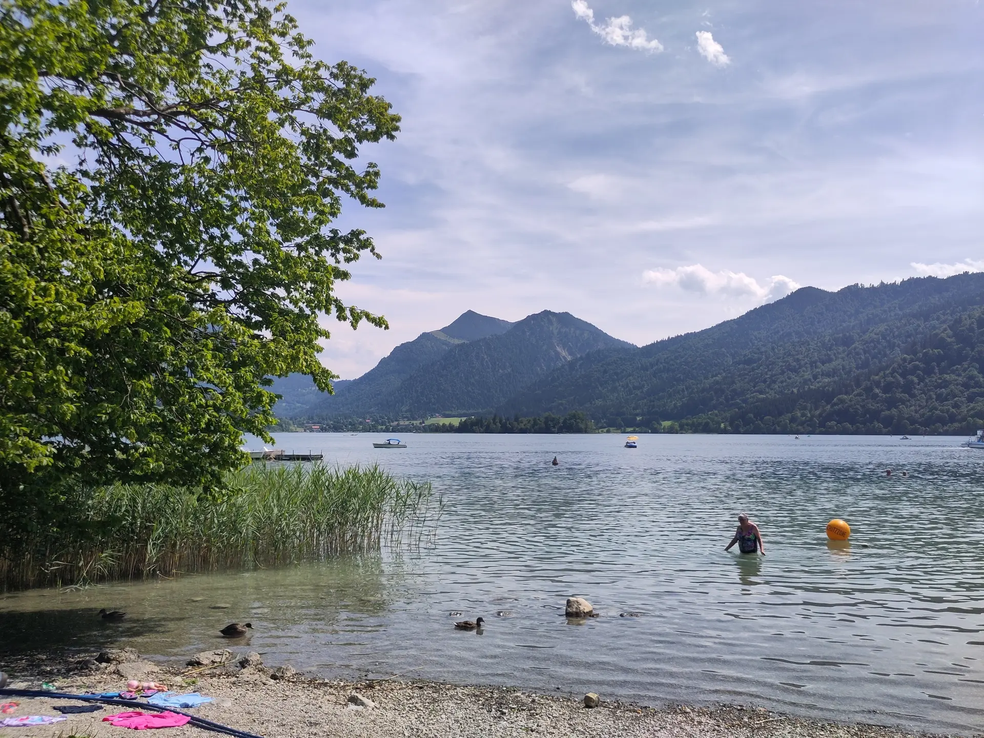 Ein See mit einem Badenden, im Hintergrund Berge | © Patrick Schönfeldt