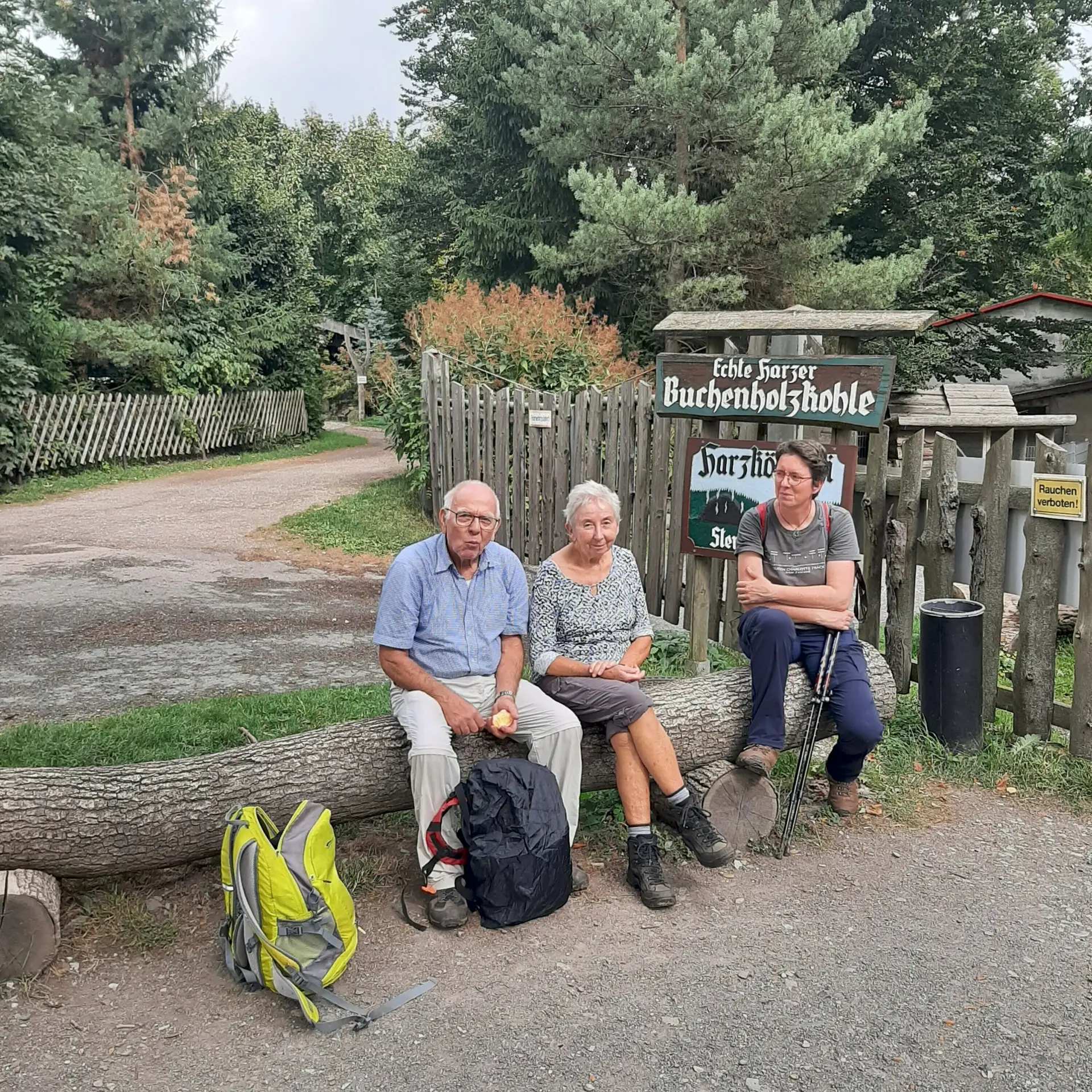 Teilnehmer einer Wanderung sitzen vor dem Eingang zum Köhlereimuseum im Harz | © Beate Straube