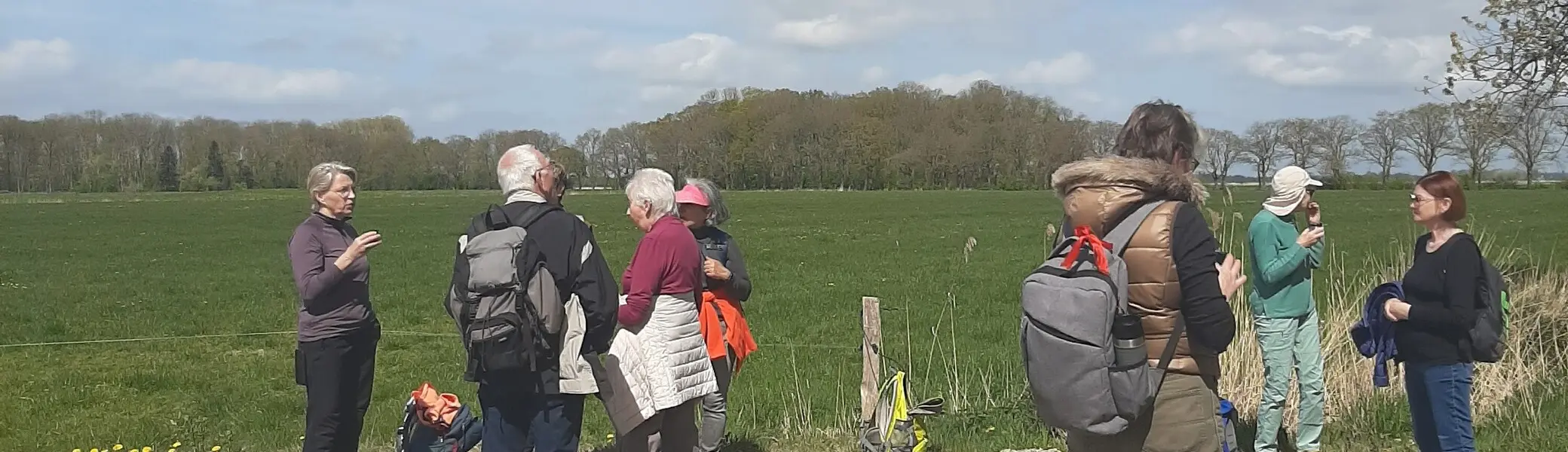Wandergruppe bei der Rast, im Hintergrund Wiese | © Beate Straube