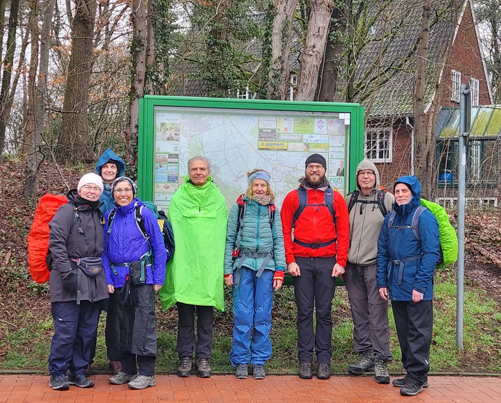 Wandergruppe vor einem Schaukasten mit Ortsbeschreibung am Bahnhof Sandkrug | © Edda Potthast