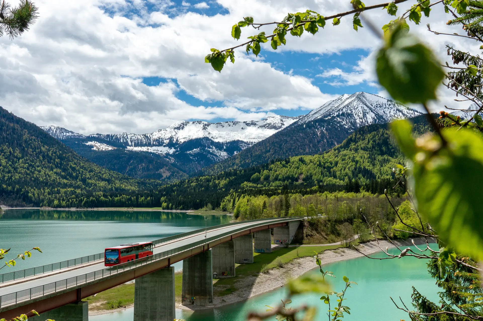 Der Bergbus des Deutschen Alpemvereins fährt über eine Brücke in die Alpen | © DAV/Tobias Hipp